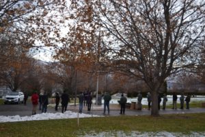 Volunteers gather (distanced) around flagpole for opening of Wreaths Across America event