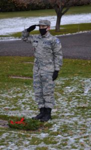 Civil Air Patrol cadet saluting after placing wreath on headstone