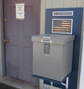 Flag Depository box with sign, and building entrance next to it