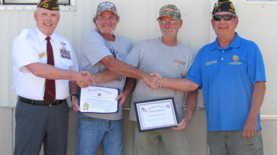 Commander Pieratt, Don and Dan Smith, and Dick Winn shaking hands and holding certificates