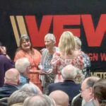 Group of people in front of VFW backdrop having their photo taken.