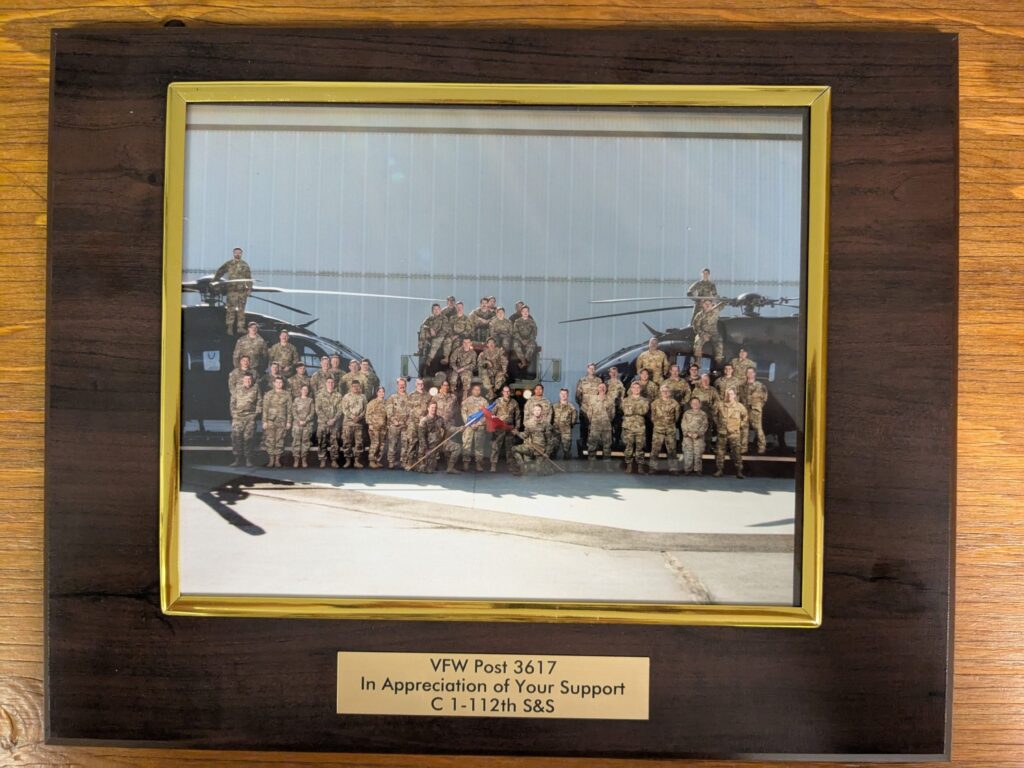 Framed photo of Army National Guard unit in uniform standing in front of helicopters
