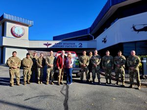 uniformed service members stand in front of their building