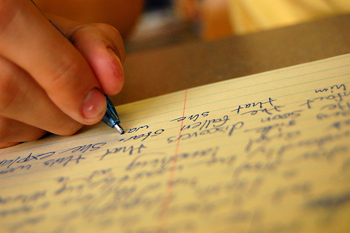hand writing an essay with pen
